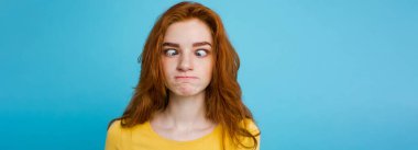 Komik surat kameraya bakarak mutlu Kızıl kızıl saçlı kızla headshot portresi. Pastel mavi arka plan. Kopya alanı.