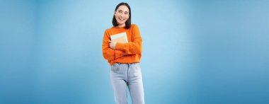 Notları olan gülümseyen Asyalı kadın, mutlu yüzlü öğrenci, üniversite eğitiminin tanıtımı, mavi arka plan..