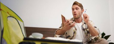 Bavul hazırlayan turistlerin portresi, listeyi gözden geçirmek, bavuluna koymak için eşyalar yazmak, deftere not almak, yatağa oturmak..