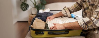 Erkek eller, elbiselerini bavula koyan turistler, valizlerin içine eşya koymalar, tatile çıkmaya hazırlanmalar, ya da iş seyahatlerine çıkmalar..