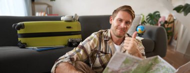 Gülümseyen adam, turist, yol haritası, baş parmağını kaldırma, tatil yeri tavsiye etme, bir gezi planlama..