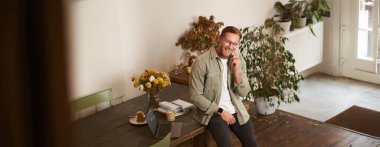 Yakışıklı ofis müdürünün portresi, çalışma alanında çalışan adam, cep telefonuyla konuşan, birini arayan, gülen ve gülümseyen, hoş sohbet yapan, masada oturan..