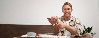 Turist portresi notlarını kontrol ediyor, tatil için eşya listesi yapıyor, fikirler yazıyor, bavul hazırlıyor, yatağa oturuyor, tatile hazırlanıyor..