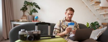 Uçuş biletleri ve pasaportuyla ilgilenen somurtkan adamın portresi dizüstü bilgisayarında açıldı..