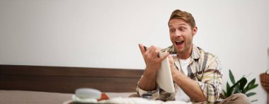 Karizmatik, yakışıklı bir adamın portresi. Deftere bakan bir turist. Yolculuğa hazırlanıyor..