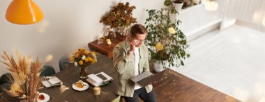 Yakışıklı genç adamın portresi dizüstü bilgisayarla oturur, konsantre ve düşünceli bir yüzle ekrana bakar, bir proje üzerinde çalışır, ortak çalışma alanında e-öğrenme, kahve içer.