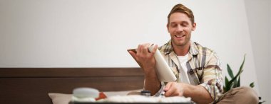 Bavul hazırlayan turistlerin portresi, listeyi gözden geçirmek, bavuluna koymak için eşyalar yazmak, deftere not almak, yatağa oturmak..