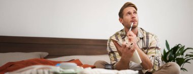 Düşünceli genç bir adamın portresi, tatile çıkan bir turist, tatil listelerini gözden geçiriyor, seyahat etmek istediği şeyleri yazıyor..