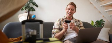 Tatile çıkan adamın portresi, kredi kartına bakmak, internetten bilet almak, web sitesinden otel kiralamak, tatil için hazırlanmak..