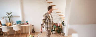 Evinde bavuluyla dolaşan, tatile çıkan, kiralık dairesinden bavuluyla çıkan yakışıklı bir adamın dikey portresi..