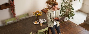 Yakışıklı yönetici, gözlüklü adam masaya oturur, dizüstü bilgisayarı ve yazıları tutar, mesaj gönderir, proje üzerinde çalışır, kahve içer, iş yerinde ya da ofiste vakit geçirir..