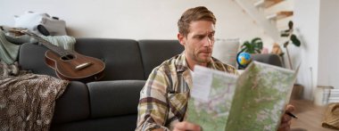 İnsan portresi, gezgin haritada şaşkın görünüyor, tatile ya da iş gezisine gitmek için rotayı öğreniyor. Turizm konsepti