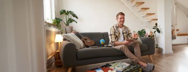 Çantalı gülümseyen adamın portresi, defterindeki notlara bakması, tatil için listeyi kontrol etmesi..