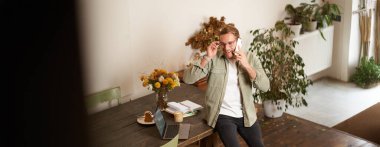 Ofisteki bir adamın portresi, iş adamı telefon görüşmesi yapıyor, telefonla konuşuyor, telefon görüşmesi yapıyor, ofiste duruyor, masaya yaslanıyor..