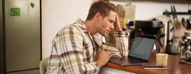 Yetişkin bir adamın bilgisayar ekranına bakması, monitörüne bakması, internette zor işler yapması, kafede oturması, kahve içmesi ve çalışması..