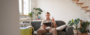 Adam bir dilek diliyor, dijital tablete bakıyor, bavulunu hazırlıyor ve tatile çıkıyor, seyahat acentesinin internet sitesini seçiyor. Boşluğu kopyala