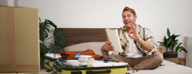 Neşeli bir adamın resmi, tamam işareti gösterir, bavuluna kıyafet koyar, tatile ya da iş seyahatine çıkar, yanında götüreceği eşyaların listesi olan bir defter tutar. Boşluğu kopyala