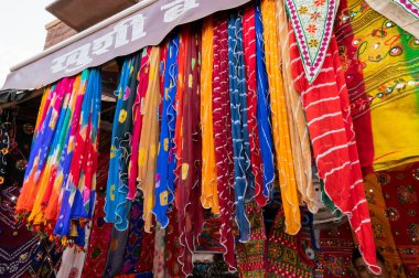 Jodhpur, Rajasthan, Hindistan - 20.10.2019: Rajasthani kadınlarının giysileri satılık, akşam saatlerinde ünlü Sardar Market ve Ghanta ghar saat kulesinde sergileniyor.