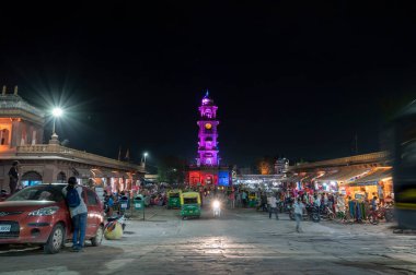 Jodhpur, Rajasthan, Hindistan - 18.10.2019: Ünlü Sardar Market ve Ghanta ghar 'ı çeken kadın fotoğrafçı, gece Jodhpur, Rajasthan, Hindistan' da saat kulesi.