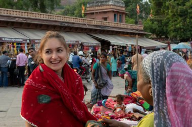 Jodhpur, Rajasthan, Hindistan - 20.10.2019: Rajasthani kadın giysileri satın alan yabancılar, akşamları Ünlü Sardar Pazarı ve Ghanta Ghar Saat Kulesi 'nde satılıyor.