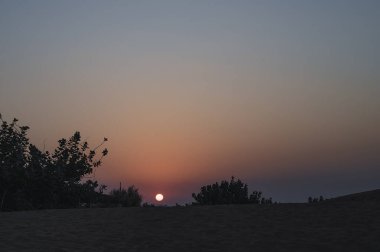 Hindistan, Rajasthan 'daki Thar Çölü' nün ufkundan yükselen güneş. Hindistan 'ın dört bir yanından turistler Thar Çölü' nde çöl güneşinin doğuşunu izlemek için geliyorlar..