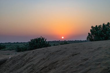 Hindistan, Rajasthan 'daki Thar Çölü' nün ufkundan yükselen güneş. Hindistan 'ın dört bir yanından turistler Thar Çölü' nde çöl güneşinin doğuşunu izlemek için geliyorlar..