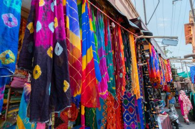 Jodhpur, Rajasthan, Hindistan - 20.10.2019: Rajasthani kadınlarının giysileri satılık, akşam saatlerinde ünlü Sardar Market ve Ghanta ghar saat kulesinde sergileniyor.