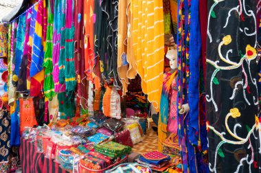 Jodhpur, Rajasthan, Hindistan - 20.10.2019: Rajasthani kadınlarının giysileri satılık, akşam saatlerinde ünlü Sardar Market ve Ghanta ghar saat kulesinde sergileniyor.