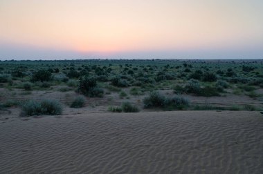 Hindistan, Rajasthan 'daki Thar Çölü' nün ufkundan yükselen güneş. Hindistan 'ın dört bir yanından turistler Thar Çölü' nde çöl güneşinin doğuşunu izlemek için geliyorlar..