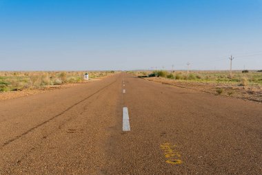 Çölde bir sabah, boş bir anayol ya da çölün içinden geçen ulusal bir yol. Uzak ufuk, Thar Çölü 'nde sıcak yaz, Rajasthan, Hindistan.