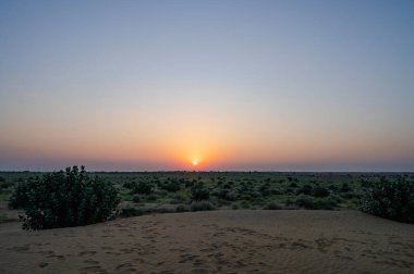 Hindistan, Rajasthan 'daki Thar Çölü' nün ufkundan yükselen güneş. Hindistan 'ın dört bir yanından turistler Thar Çölü' nde çöl güneşinin doğuşunu izlemek için geliyorlar..