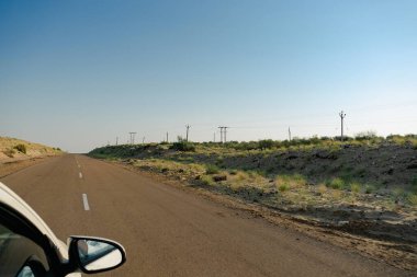 Beyaz araba boş anayoldan mı geçiyor yoksa çölden geçen ulusal yoldan mı geçiyor? Uzak ufuk, Thar Çölü 'nde sıcak yaz, Rajasthan, Hindistan.