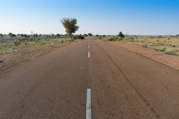 stock image Morning in desert with empty high road or national high way passing through the desert. Distant horizon, Hot summer at Thar desert, Rajasthan, India.