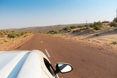 Beyaz araba boş anayoldan mı geçiyor yoksa çölden geçen ulusal yoldan mı geçiyor? Uzak ufuk, Thar Çölü 'nde sıcak yaz, Rajasthan, Hindistan.