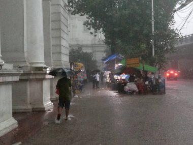 Kolkata, Batı Bengal, Hindistan - 16 Ağustos 2019: Hint müzesi yakınlarındaki su dolu patikada yürüyen yayalar. Kolkata 'da muson yağmurları,