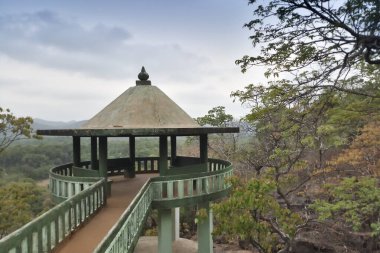 Viewpoint. Forest seen from viewpoint with cloudy sky, distant mountains in the background and forest in the foreground. Karnataka, India.
