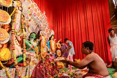 Howrah, Batı Bengal, Hindistan - 14 Ekim 2021: Hindu Purohit Sanskrit shlokas 'ın tanrıça Durga' ya itme hareketi, tanrıçaya çiçeklerle tapınma ritüeli.