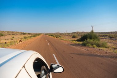 Beyaz araba boş anayoldan mı geçiyor yoksa çölden geçen ulusal yoldan mı geçiyor? Uzak ufuk, Thar Çölü 'nde sıcak yaz, Rajasthan, Hindistan.