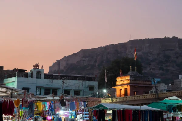 stock image Jodhpur, Rajasthan, India - 19.10.2019 : Blue hour image of famous Sardar Market and Ghanta ghar Clock tower in Jodhpur, Rajasthan, India. Mehrangarh fort or Jodhpur fort in background.