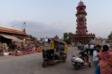 Jodhpur, Rajasthan, Hindistan - 20.10.2019: Meşgul ve tıklım tıklım çalışan Sardar Pazarı ve Hindistan 'ın Rajasthan kentindeki Ghanta ghar saat kulesi.