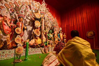 Howrah, Hindistan - 13 Ekim 2021: Hindu Rahibi Tanrıça Durga 'ya tapıyor. Ashtami puja aarati - kutsal Durga Puja ritüeli - gece çekildi.