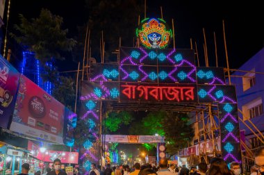 Kolkata, West Bengal, India - 12th October 2021 : Huge welcome gate for Bagbazar Durga Puja, UNESCO Intangible cultural heritage of humanity. Devotees rushing to visit famous Puja pandal at night.