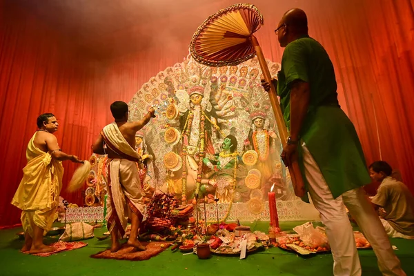 stock image Howrah, India -October 13, 2021 : Hindu Priests worshipping Goddess Durga with panchapradip, ghanta, chamor and hand fan. Ashtami puja aarati - sacred Durga Puja ritual - shot at night.