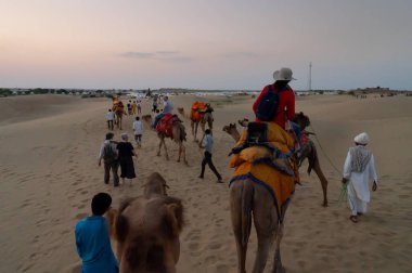 Thar Çölü, Rajassthan, Hindistan - 15 Ekim 2019: Thar Çölü 'nün kum tepelerinde deveye binen turistler. Deve sürmek burayı ziyaret eden tüm turistler arasında favori bir etkinliktir.,