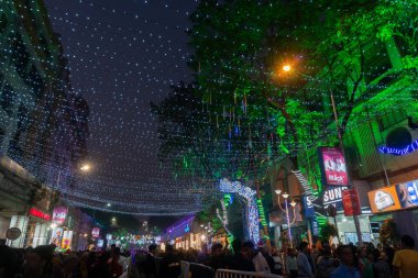 Kolkata, Batı Bengal, Hindistan - 26.12.2018: Aydınlatılmış ve dekore edilmiş park caddesinde coşkulu genç halk tarafından Noel kutlaması ve yıl sonu şenlik havası. Akşam gökyüzü arkaplanı.