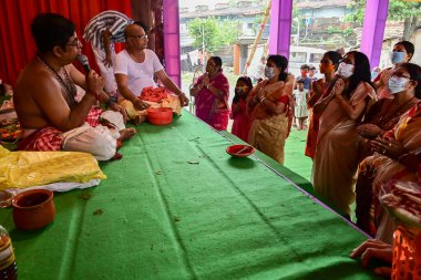 Howrah, Batı Bengal, Hindistan - 14 Ekim 2021 Hindu Purohit Hindu dindarlar için Sanskritçe shloka 'lar söyleyerek tanrıça Durga' ya itme ayini, çiçeklerle tanrıçaya tapınma ritüeli.