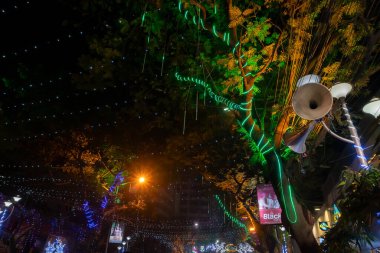 Kolkata, Batı Bengal, Hindistan - 25.12.2018: Aydınlatılmış ve dekore edilmiş park caddesinde coşkulu genç halk tarafından Noel kutlaması ve yıl sonu şenlik havası. Akşam gökyüzü arkaplanı.
