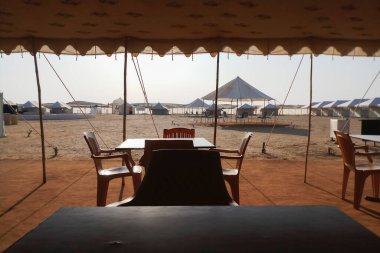 Hindistan, Rajasthan 'daki Thar çölündeki bir çöl kampında turistler için masa ve sandalyeler düzenleniyor..