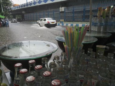 Kolkata, Batı Bengal, Hindistan - 16 Ağustos 2019: Arka planda muson yağmurları altında bir yol kenarı dükkânı ıslanıyor. Sarı taksi bekliyor. Kolkata 'nın yağışlı sezonu,