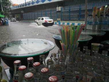 Kolkata, West Bengal, India - 16th August 2019 : A roadside shop is being wet under monsoon raining, waterlogged road in the backgrounnd. Yellow taxi waiting . Rainy season of Kolkata, clipart